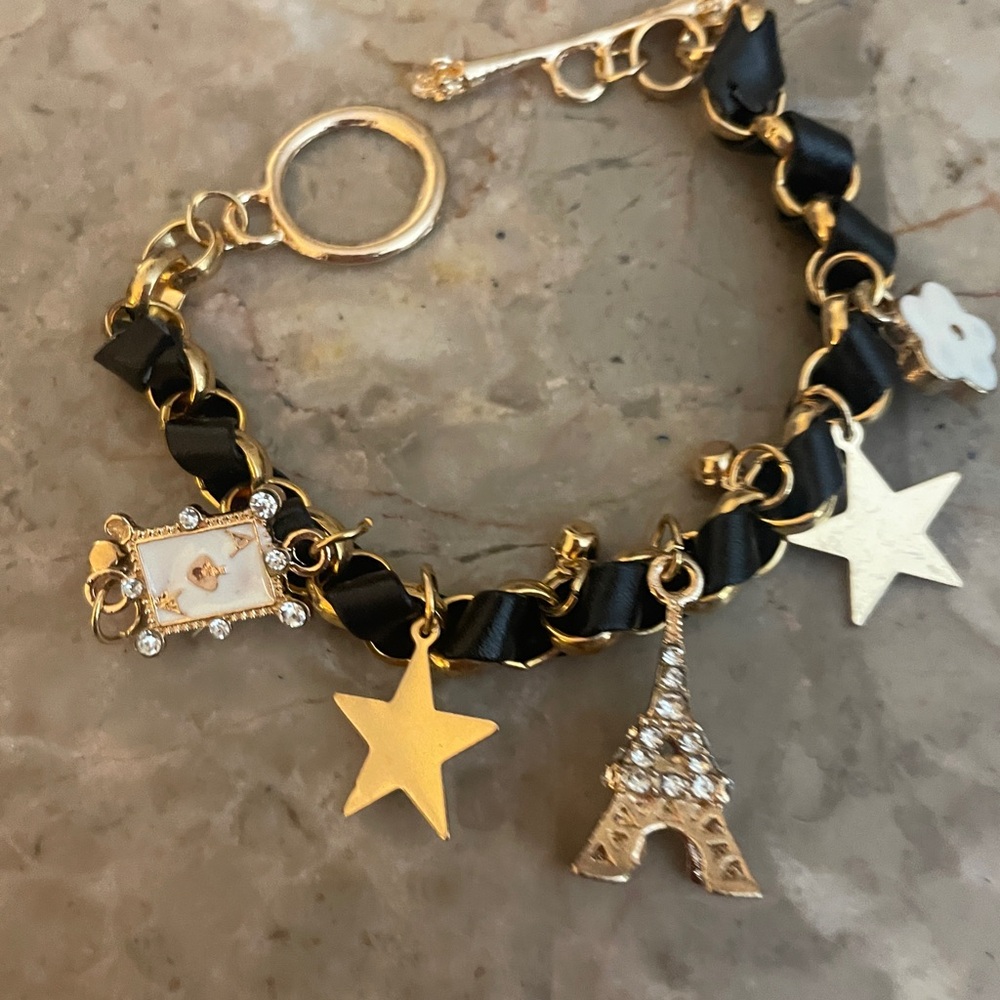 Cute gold tone and black bracelet with Eiffel Tower ace of spades, flower.